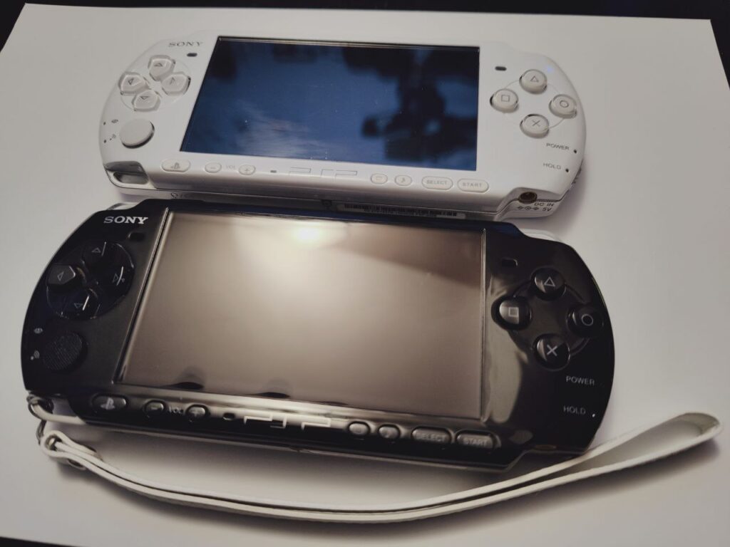 2 PSPs laying on the table - black and white
