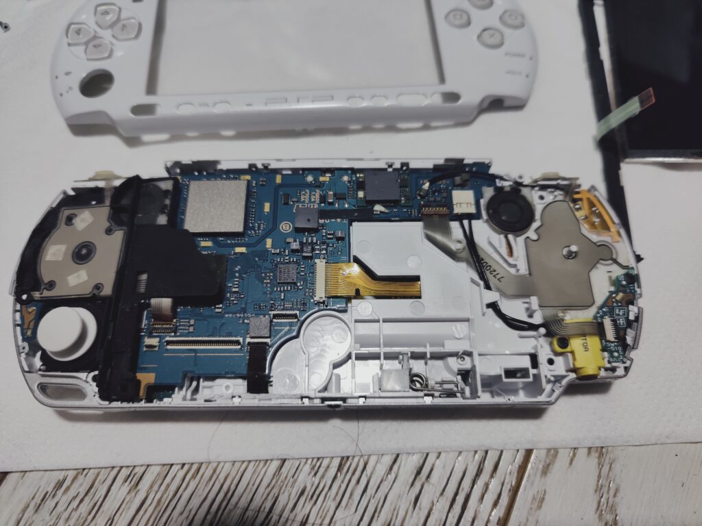 PSP 3000 fully open. You can see the motherboard and other internals. Process of PSP reshell