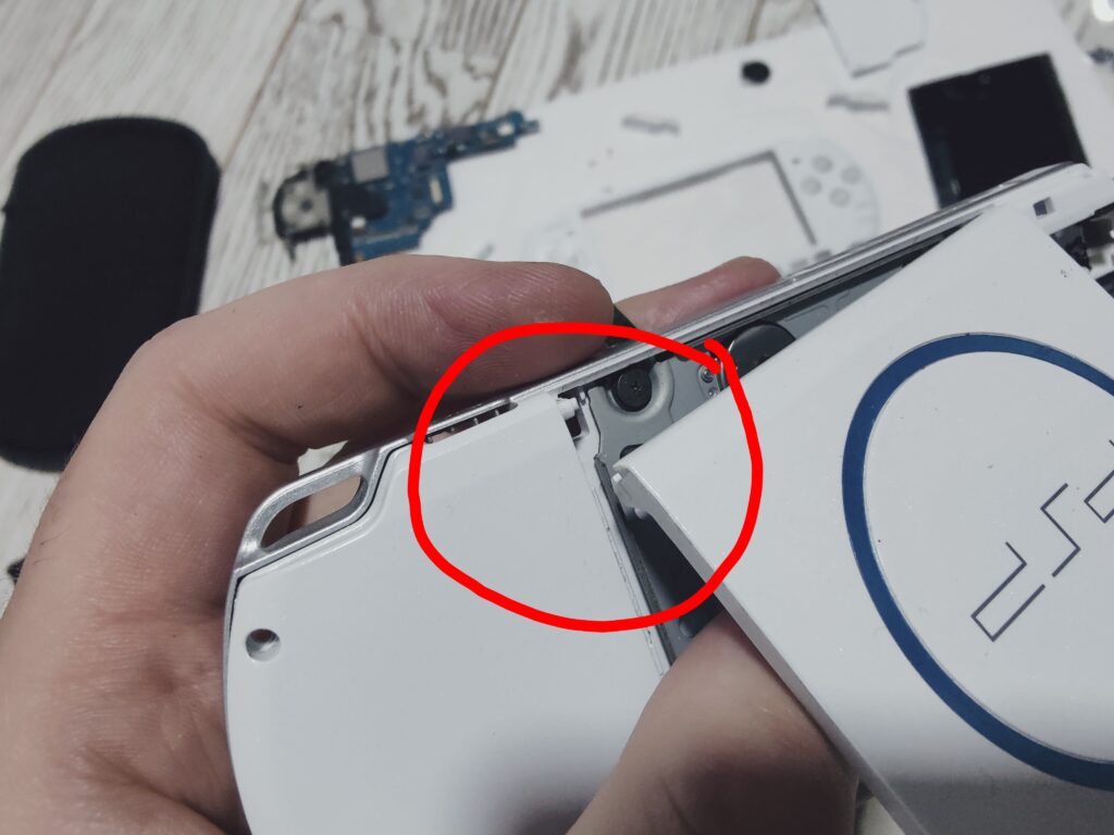 Pin of PSP's disk bay cover where cover is attached. Process of PSP disassembly