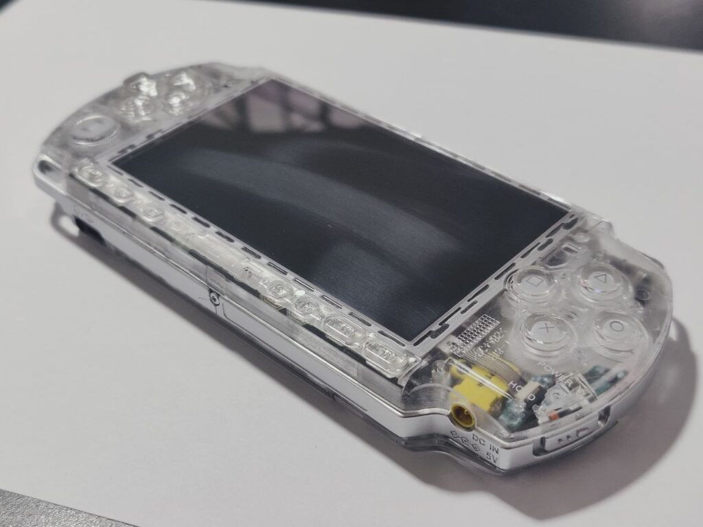 PSP 3000 in transparent case laying on the table